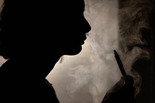 A person poses for a photograph as they vape in Melbourne, March 23, 2023. Recreational vaping will be banned as the government seeks to prevent the next generation of nicotine addicts, Australia&rsquo;s Health Minister Mark Butler said on Tuesday, May 2, 2023.(Diego Fedele/AAP Image via AP)