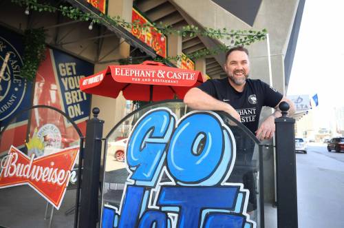 Ruth Bonneville / Free Press
                                Dwight Benson, general manager of Elephant and Castle on their outdoor patio which is decorated to promote the Jets during their White-out street parties.