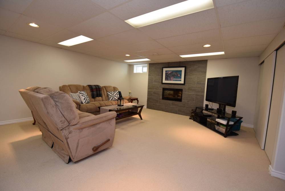 TODD LEWYS / FREE PRESS
The highlight of the huge lower-level rec room is a spacious media area complemented by an electric fireplace set in a grey-tile surround.
