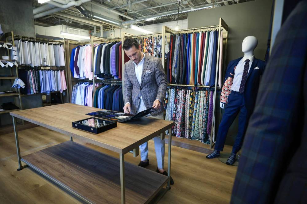 RUTH BONNEVILLE / FREE PRESS
Eph Apparel co-founder Andrew Parkes peruses a sample book in the firm’s showroom at 190 Smith St. The company is hosting a grand reopening for its newly renovated space on Saturday. It also boasts a Calgary location.