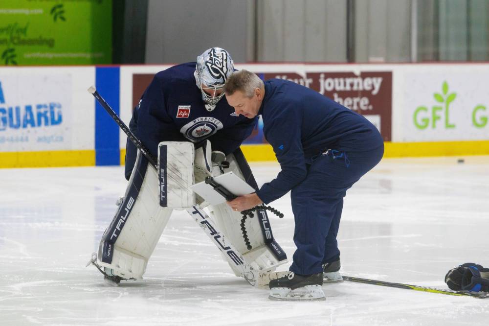 MIKE DEAL / FREE PRESS FILES
Winnipeg Jets goaltender Connor Hellebuyck (left) reviews footage with goalie coach Wade Flaherty during practice at the Hockey For All Centre. Hellebuyck says one of Flaherty’s greatest assets is that “he knows the mental side of things.”