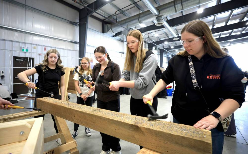 Ruth Bonneville / Free Press
Kenneth Neumann, a Grade 10 student at St. Paul’s Collegiate in Elie, climbs a utility pole alongside schoolmate Jonas Dufresne (right) at Red River Exhibition Place on Wednesday as part of the 2025 Manitoba Construction Career Expo.