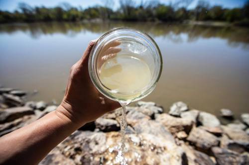 MIKAELA MACKENZIE / FREE PRESS A jar of unclear river water by the Red River.
