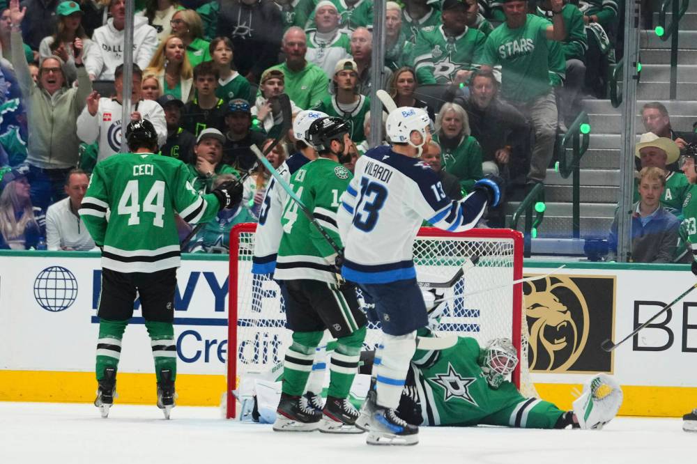 Julio Cortez / The Associated Press
Winnipeg Jets’ Gabriel Vilardi celebrates a goal scored by Kyle Connor, as Dallas Stars goaltender Jake Oettinger lies on the ice in the first period.