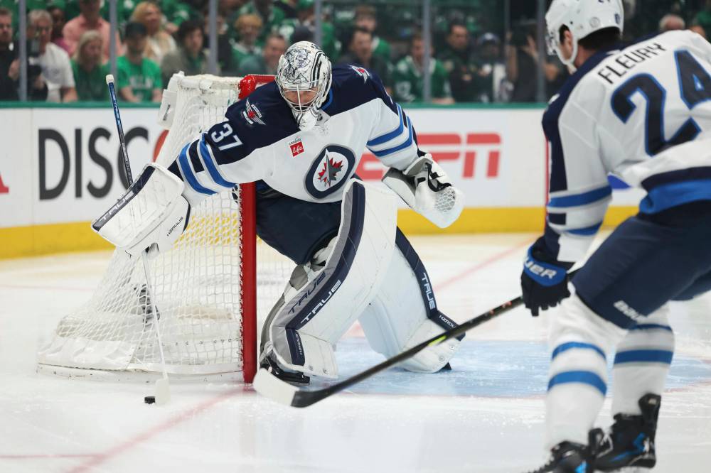 Gareth Patterson / The Associated Press
Winnipeg Jets goaltender Connor Hellebuyck cotrols the puck and as Haydn Fleury moves in to take control in the first period.