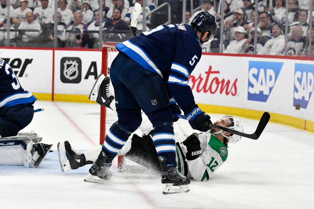 Fred Greenslade / CANADIAN PRESS
Dallas Stars’ Sam Steel is checked to the ice by Winnipeg Jets’ Luke Schenn during the first period.