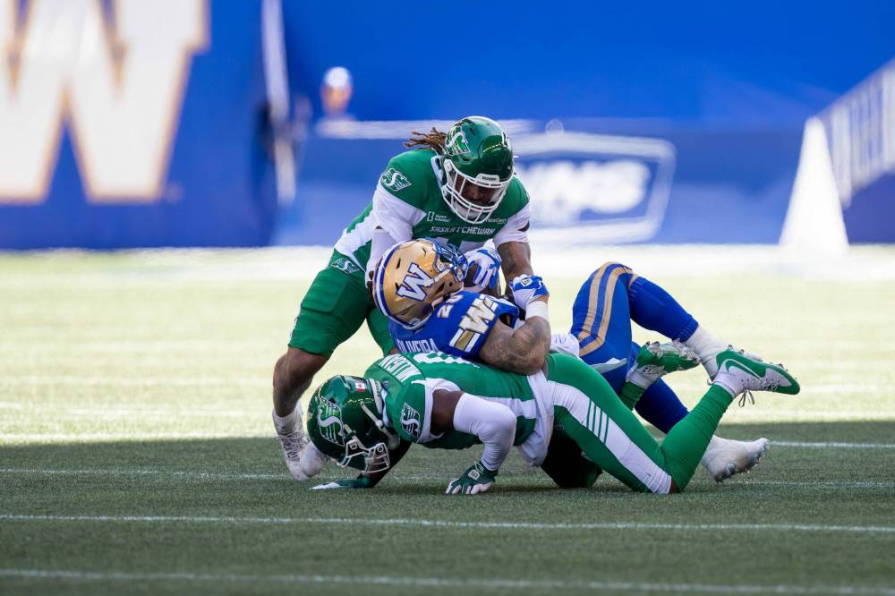 BROOK JONES/FREE PRESS
Winnipeg Blue Bombers running back Brady Oliveira (No. 20) is tackled by Riders linebacker Aubrey Miller (No. 47) and defensive back Rolan Milligan Jr. (No. 0) during first quarter action Saturday at Princess Auto Stadium in Winnipeg. The Bombers earned a 15-9 victory over the Riders.