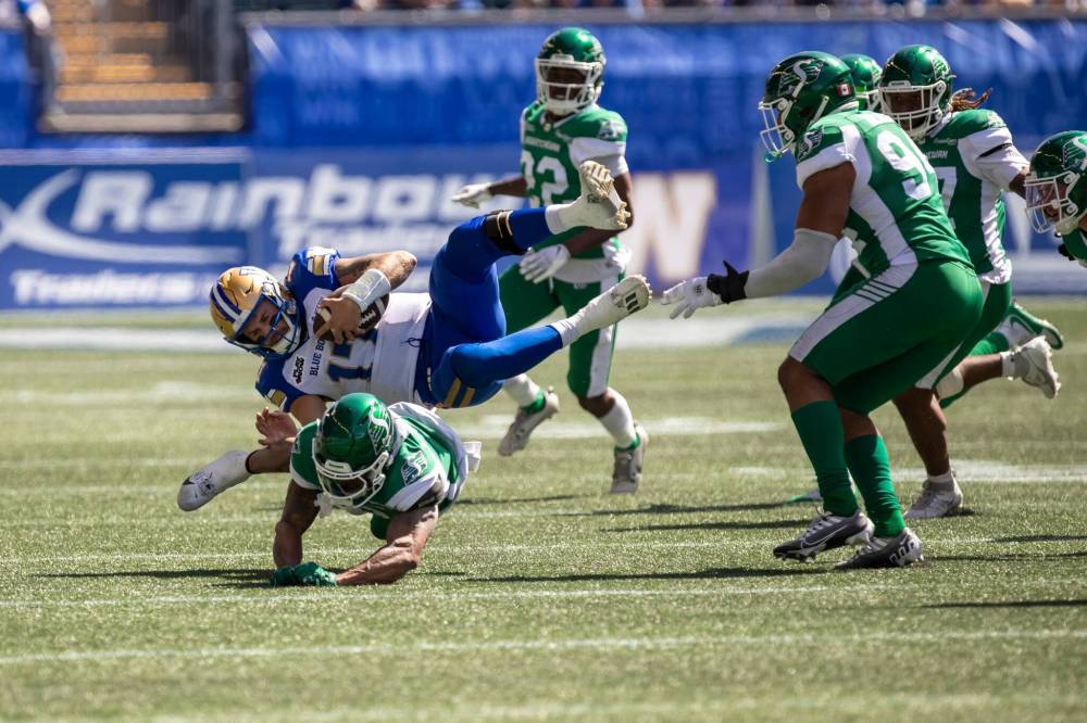 BROOK JONES/FREE PRESS Bombers quarterback Chris Streveler (No. 17) is thrown into the air with a hit by Riders defensive back Marcus Sayles (No. 8) during second quarter action on Saturday.
