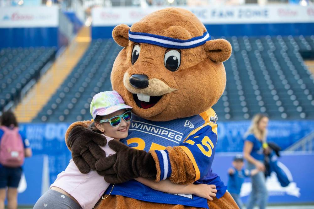 BROOK JONES/FREE PRESS The Winnipeg Blue Bombers host the visiting Saskatchewan Roughriders in Canadian Football league preseason action at Princess Auto Stadium in Winnipeg, Man., Saturday, May 24, 2025. The Bombers earned a 15-9 victory over the Riders. Pictured: Nine-year-old Kiera Wetton gives 2025 Grey Cup mascot Justin Beaver a hug after the game.