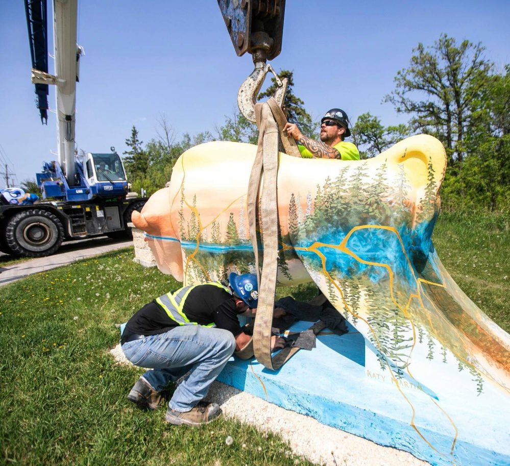 MIKAELA MACKENZIE / FREE PRESS
                                Reiss DeBraga (left) and Chris Pilloud with Able Crane Services placing one of the pieces at the installation site.
