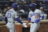 Los Angeles Dodgers' Teoscar Hernández, right, reacts after scoring on a single hit by Andy Pages with Michael Conforto, left, during the fifth inning of a baseball game against the New York Mets, Friday, May 23, 2025, in New York. (AP Photo/Pamela Smith)