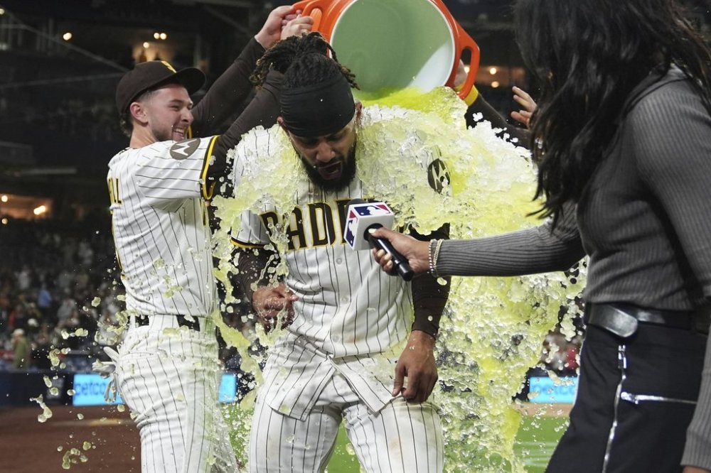 San Diego Padres' Fernando Tatis Jr., center, is doused by teammate center fielder Jackson Merrill, left, after hitting a game-winning two-run home run to defeat the Los Angeles Angels 6-4 in a baseball game Tuesday, May 13, 2025, in San Diego. (AP Photo/Gregory Bull)