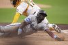 Miami Marlins' Ronny Simon, front, slides in safely to score from third base off a sacrifice fly by Javier Sanoja as San Diego Padres catcher Elias Diaz is late with the tag during the first inning of a baseball game Tuesday, May 27, 2025, in San Diego. (AP Photo/Gregory Bull)