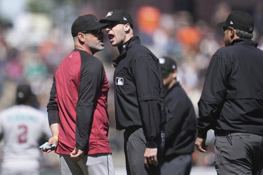 Arizona Diamondbacks manager Torey Lovullo, left, argues with umpire Nic Lentz, middle, after being ejected by Mark Ripperger, right, during the eighth inning of a baseball game against the San Francisco Giants in San Francisco, Wednesday, May 14, 2025. (AP Photo/Jeff Chiu)