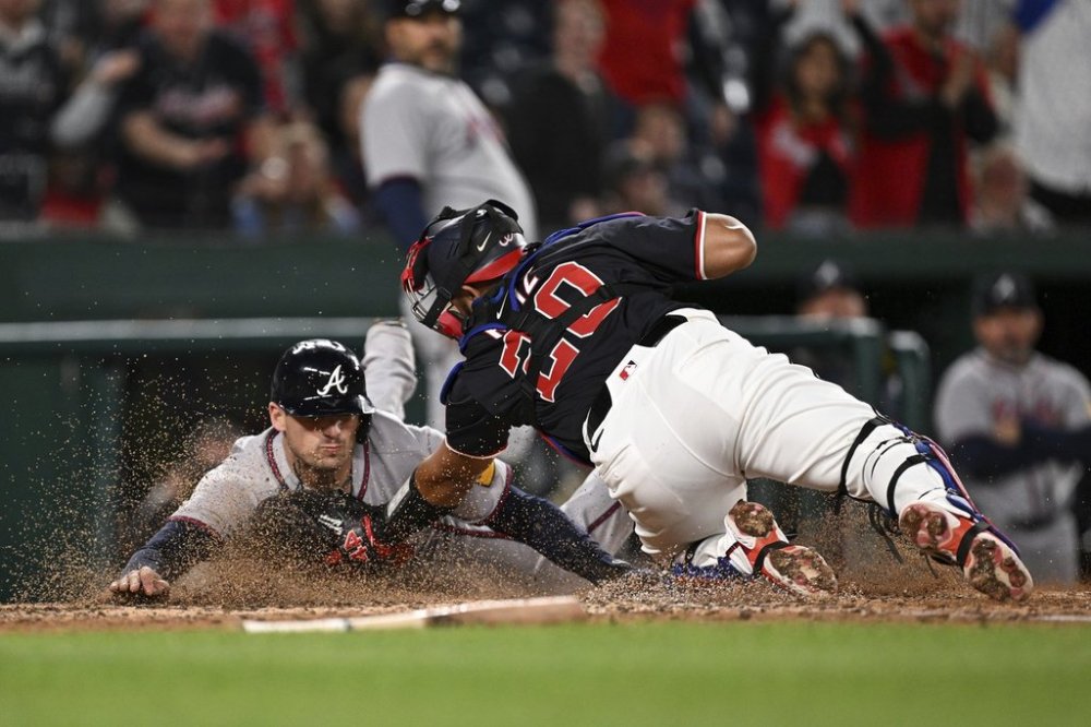 Atlanta Braves' Austin Riley is tagged out by Washington Nationals catcher Keibert Ruiz (20) as he attempts to score a run after a double hit by Matt Olson against pitcher Kyle Finnegan during the ninth inning of a baseball game in Washington, Thursday, May 22, 2025. (AP Photo/Terrance Williams)