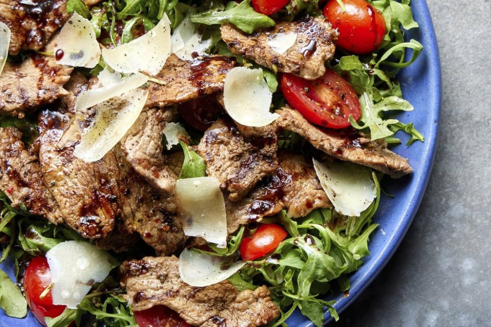 This image released by Milk Street shows a recipe for straccetti di manzo, made with steak with arugula and parmesan. (Milk Street via AP)