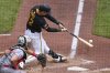 Pittsburgh Pirates' Henry Davis singles off Cincinnati Reds pitcher Brady Singer, driving in a run, during the fourth inning of a baseball game in Pittsburgh, Wednesday, May 21, 2025. (AP Photo/Gene J. Puskar)