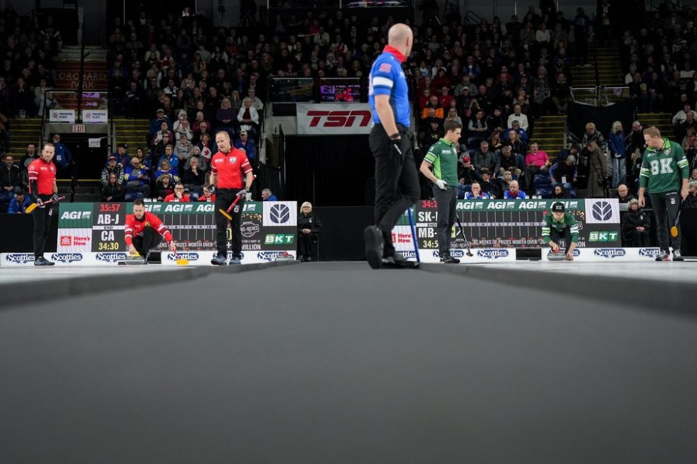 Canada skip Brad Gushue, back left, playing Alberta-Jacobs and Saskatchewan-McEwen skip Mike McEwen, back right, playing Manitoba-Dunstone, prepare to deliver rocks during the playoffs at the Montana's Brier in Kelowna, B.C., on Friday, March 7, 2025. THE CANADIAN PRESS/Darryl Dyck