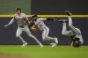 Baltimore Orioles' Jackson Holliday (7), Cedric Mullins (31), and Ramón Laureano, right, are unable to reach a fly ball during the fourth inning of a baseball game against the Milwaukee Brewers, Tuesday, May 20, 2025, in Milwaukee. (AP Photo/Aaron Gash)