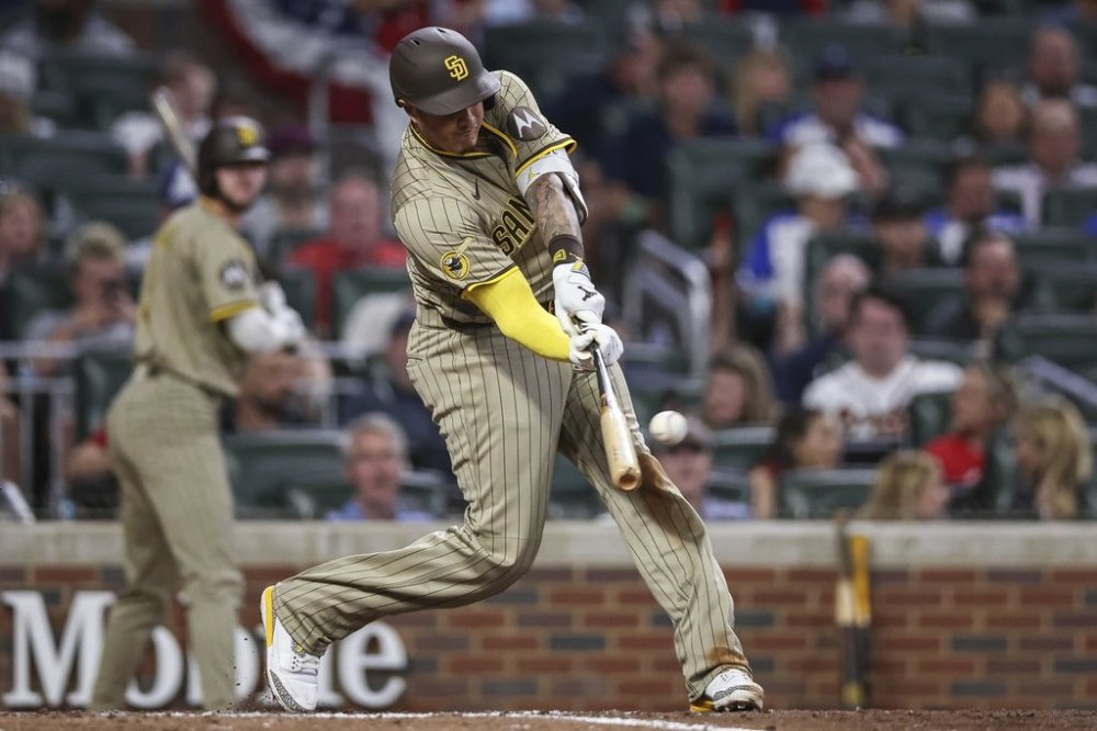 San Diego Padres' Manny Machado hits a home run in the ninth inning of a baseball game against the Atlanta Braves, Friday, May 23, 2025, in Atlanta. (AP Photo/Colin Hubbard)
