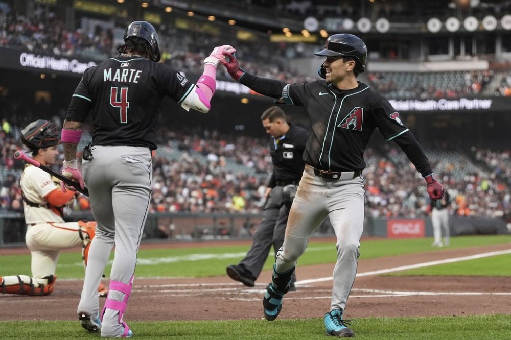 Arizona Diamondbacks' Corbin Carroll, right, is congratulated by Ketel Marte (4) after hitting a home run against the San Francisco Giants during the third inning of a baseball game in San Francisco, Monday, May 12, 2025. (AP Photo/Jeff Chiu)