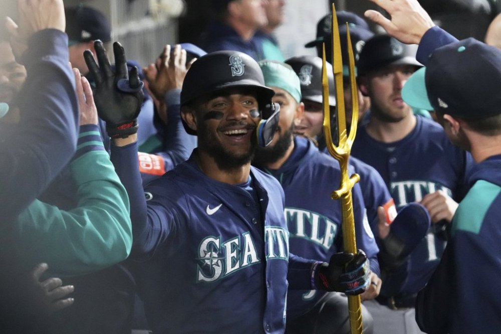 Seattle Mariners' Julio Rodríguez celebrates with teammates in the dugout after hitting a grand slam during the eighth inning of a baseball game against the Chicago White Sox in Chicago, Monday, May 19, 2025. (AP Photo/Nam Y. Huh)
