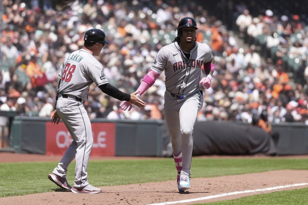 Arizona Diamondbacks' Ketel Marte, right, is congratulated by third base coach Shaun Larkin (88) after hitting a two-run home run during the fourth inning of a baseball game against the San Francisco Giants in San Francisco, Wednesday, May 14, 2025. (AP Photo/Jeff Chiu)