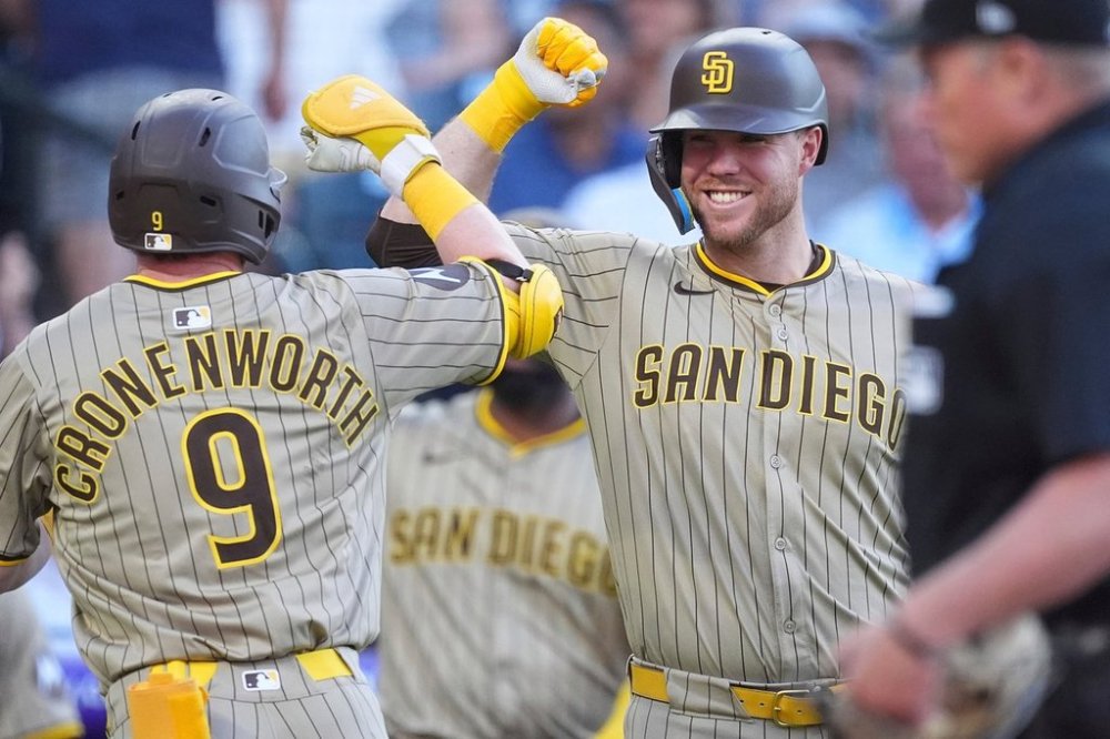 San Diego Padres' Gavin Sheets, right, congratulates Jake Cronenworth who returns to the dugout after hitting a solo home urn off Colorado Rockies starting pitcher Bradley Blalock in the third inning of a baseball game Saturday, May 10, 2025, in Denver. (AP Photo/David Zalubowski)