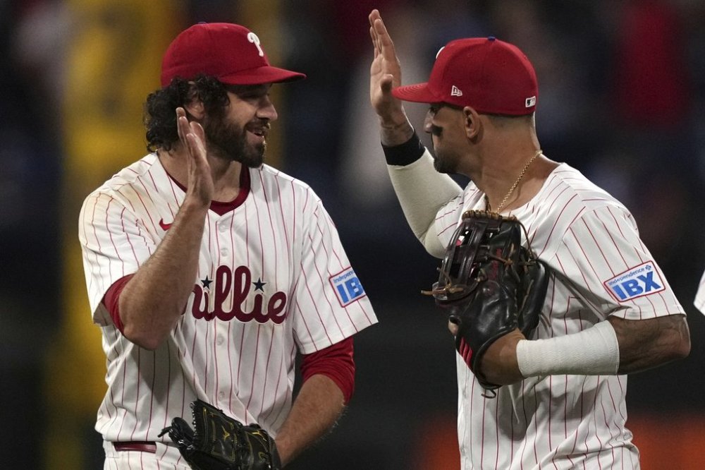 Philadelphia Phillies' Jordan Romano, left, and Nick Castellanos celebrate after the Phillies won a baseball game against the Atlanta Braves Tuesday, May 27, 2025, in Philadelphia. (AP Photo/Matt Slocum)