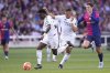 Real Madrid's Vinicius Junior, left, and Kylian Mbappe, center, go for the ball past Barcelona's Andreas Christensen during the Spanish La Liga soccer match between Barcelona and Real Madrid at the Lluis Companys Olympic Stadium in Barcelona, Spain, Sunday, May 11, 2025. (AP Photo/Jose Breton)