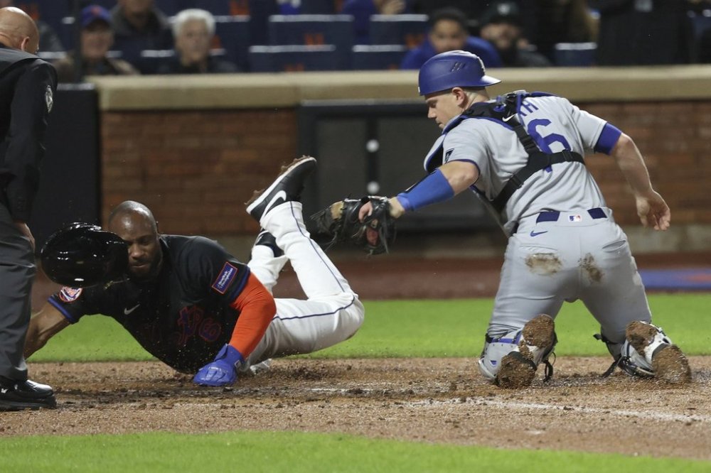 New York Mets' Starling Marte, second from right, scores against Los Angeles Dodgers catcher Will Smith, right, on a sacrifice fly hit by Pete Alonso during the fourth inning of a baseball game Friday, May 23, 2025, in New York. (AP Photo/Pamela Smith)