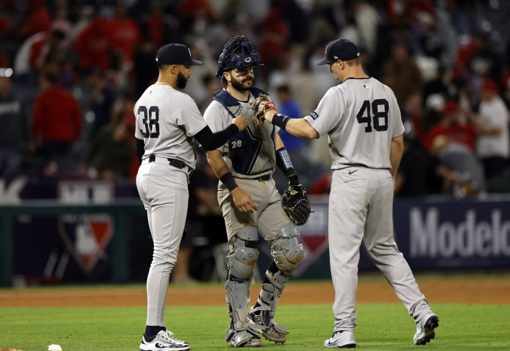 New York Yankees' Paul Goldschmidt, right, congratulates relief pitcher Devin Williams, left, and catcher Austin Wells after defeating the Los Angeles Angels, Tuesday, May 27, 2025, in Anaheim, Calif. (AP Photo/Kevork Djansezian)
