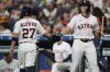 Houston Astros' Jose Altuve (27) celebrates with Jake Meyers (6) after scoring off of a single hit by Yainer Diaz during the first inning of a baseball game against the Cincinnati Reds in Houston, Saturday, May 10, 2025. (AP Photo/Ashley Landis)