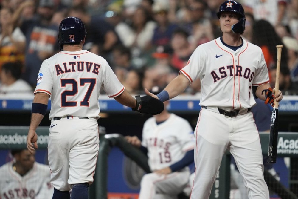 Houston Astros' Jose Altuve (27) celebrates with Jake Meyers (6) after scoring off of a single hit by Yainer Diaz during the first inning of a baseball game against the Cincinnati Reds in Houston, Saturday, May 10, 2025. (AP Photo/Ashley Landis)