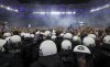 Police officers stand guard as Hamburg fans storm the pitch to celebrate promotion following a Bundesliga 2 soccer game between Hamburger SV and SSV Ulm 1846 in Hamburg, Germany, Saturday, May 10, 2025. (Christian Charisius/dpa via AP)
