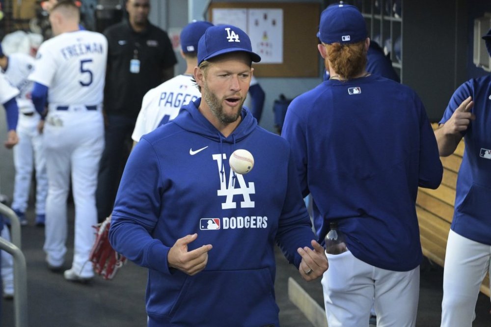 Los Angeles Dodgers' Clayton Kershaw tosses a ball as he walks through the dugout early in a baseball game against the Oakland Athletics, Wednesday, May 14, 2025, in Los Angeles. (AP Photo/Jayne Kamin-Oncea)