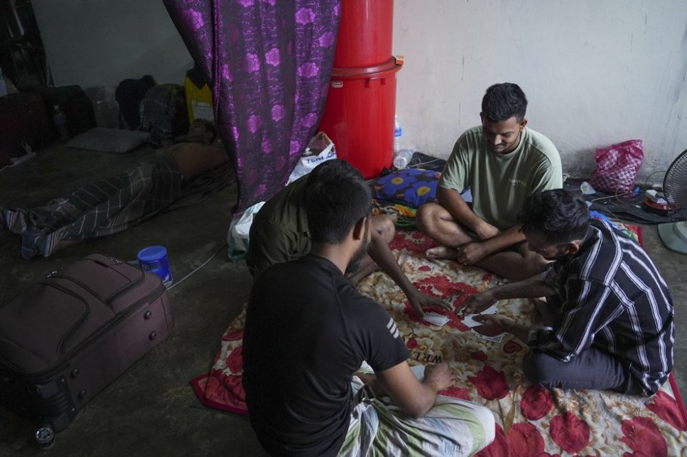 Bangladeshi migrant workers play cards in a dormitory in Klang, Malaysia, Friday, Jan. 24, 2025. (AP Photo/Azneal Ishak).