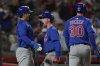 Chicago Cubs' Pete Crow-Armstrong, center, celebrates with Seiya Suzuki, left, and outfielder Kyle Tucker, right, after hitting a grand slam to right field during the seventh inning of a baseball game against the Cincinnati Reds, Friday, May 23, 2025, in Cincinnati. (AP Photo/Carolyn Kaster)