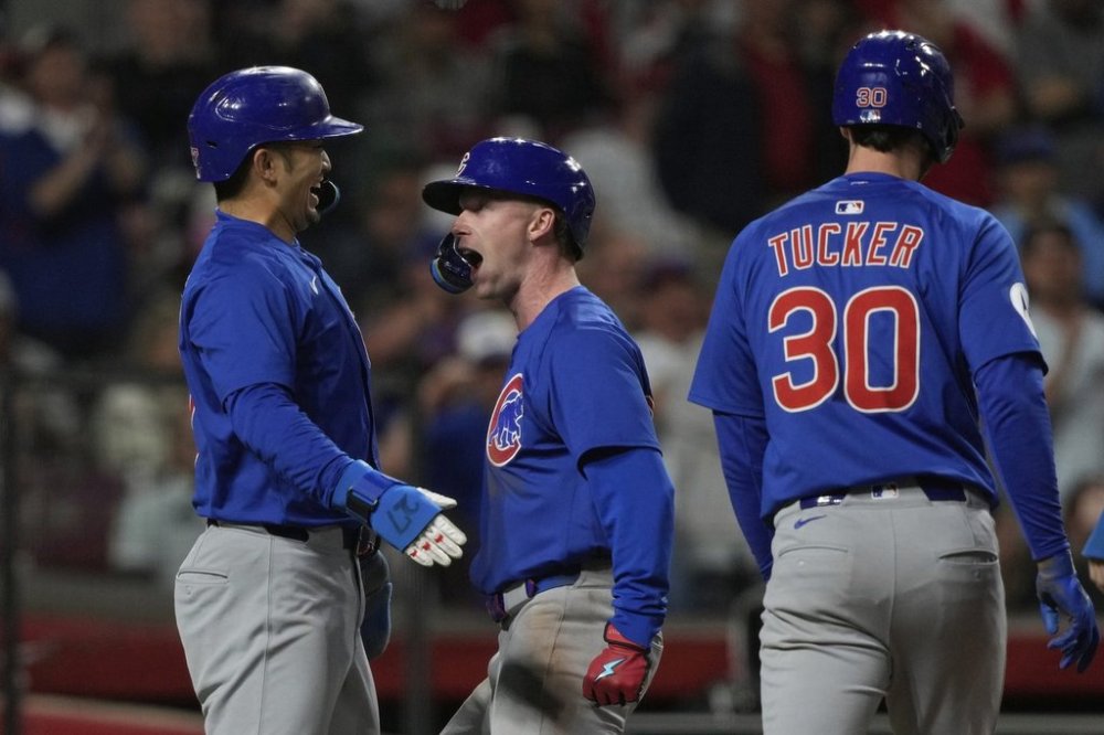 Chicago Cubs' Pete Crow-Armstrong, center, celebrates with Seiya Suzuki, left, and outfielder Kyle Tucker, right, after hitting a grand slam to right field during the seventh inning of a baseball game against the Cincinnati Reds, Friday, May 23, 2025, in Cincinnati. (AP Photo/Carolyn Kaster)