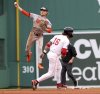 Baltimore Orioles shortstop Gunnar Henderson, left, throws to first base after tagging out Boston Red Sox's Jarren Duran (16) at second base on a double play during the fifth inning of a baseball game Sunday, May 25, 2025, in Boston. (AP Photo/Mark Stockwell)