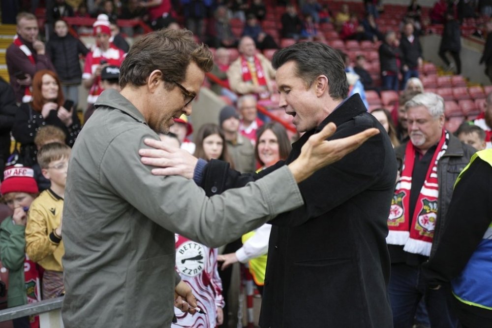 Wrexham co-owners Ryan Reynolds, left, and Rob McElhenney, right, speak before the English League One soccer match between Wrexham and Charlton Athletic at the Racecourse ground in Wrexham, Wales, Saturday, April 26, 2025. (AP Photo/Jon Super)