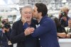 FILE - Actor Edgar Ramirez, right, kisses fellow actor Robert De Niro during a photo call for 