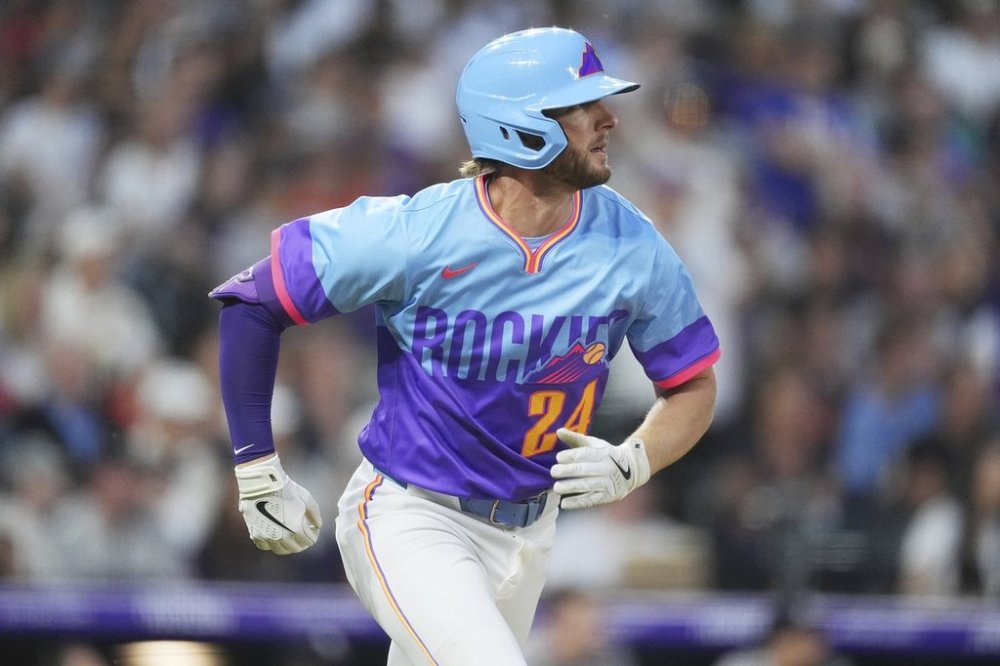 Colorado Rockies' Ryan McMahon follows the flight of his double that drove in two runs off New York Yankees relief pitcher Tim Hill in the fifth inning of a baseball game Friday, May 23, 2025, in Denver. (AP Photo/David Zalubowski)