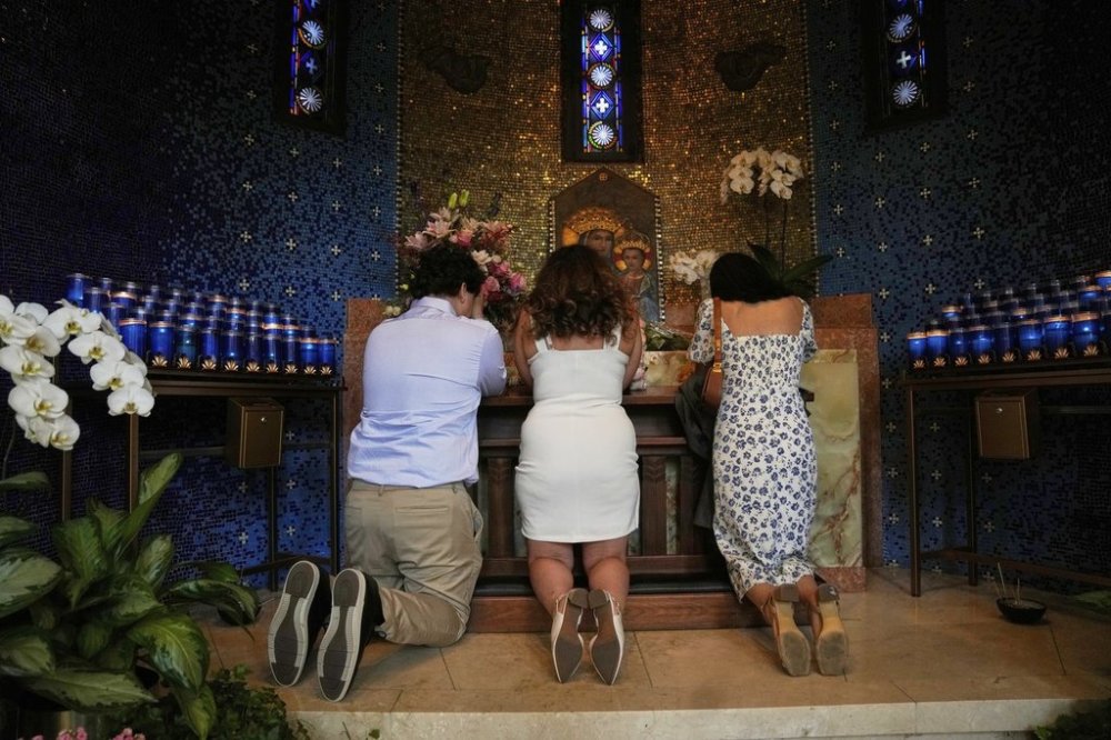 People kneel in prayer at Madonna della Strada Chapel at Loyola University Chicago shortly before Chicago-born Robert Francis Cardinal Prevost was announced as Pope Leo XIV, Thursday, May 8, 2025, in Chicago. (AP Photo/Erin Hooley)