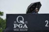 A person walks in the rain over a pedestrian bridge during a practice round for the PGA Championship golf tournament at the Quail Hollow Club, Monday, May 12, 2025, in Charlotte, N.C. (AP Photo/Matt York)