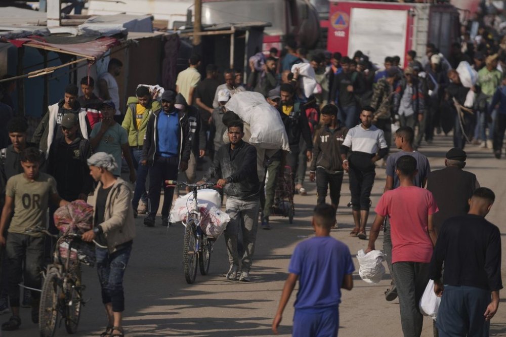Palestinians carry bags containing food and humanitarian aid packages delivered by the Gaza Humanitarian Foundation, a U.S.-backed organization approved by Israel in Khan Younis, southern Gaza Strip, Sunday, June 1, 2025. (AP Photo/Abdel Kareem Hana)
