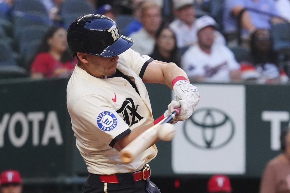 Texas Rangers Sam Haggerty hits a triple scoring teammates Kyle Higashioka and Marcus Semien during the second inning of a baseball game against the St. Louis Cardinals, Friday, May 30, 2025, in Arlington, Texas. (AP Photo/LM Otero)