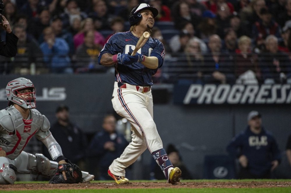 Cleveland Guardians' Jose Ramirez, right, watches his solo home run off Philadelphia Phillies relief pitcher Joe Ross as Phillies catcher Rafael Marchan, left, looks on during the seventh inning of a baseball game Friday, May 9, 2025, in Cleveland. (AP Photo/Phil Long)