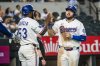 Texas Rangers' Jake Burger celebrates a run with Texas Rangers' Adolis Garcis during the eighth inning of a baseball game against the Athletics, Tuesday, April 29, 2025, in Arlington, Texas. (AP Photo/Jessica Tobias)