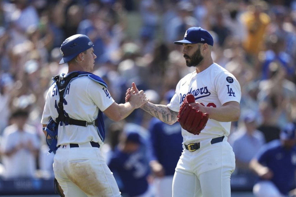 Los Angeles Dodgers catcher Will Smith (16) and pitcher Tanner Scott (66) celebrate the team's 6-5 win against the New York Mets in a baseball game Thursday, June 5, 2025, in Los Angeles. (AP Photo/Jae C. Hong)